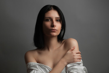 Portrait of beautiful young woman with bare shoulders. Studio