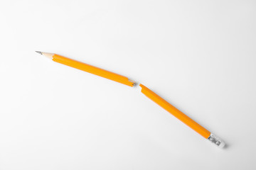 Broken graphite pencil with eraser on white background
