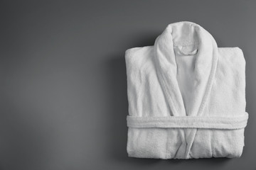 Clean folded bathrobe on grey background, top view. Space for text