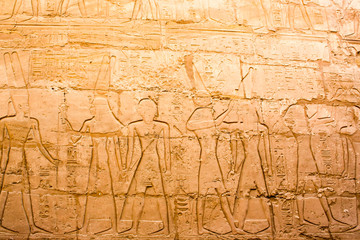 Naklejka premium Karnak temple complex in Luxor, Egypt. Ancient bas relief with hieroglyphs on wall, pharaohs and gods.