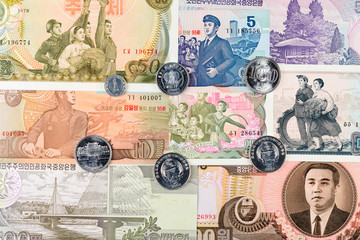 Six North Korea Won coins on a different banknotes background. DPRK money close-up macro.
