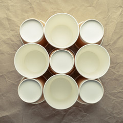 Paper cups for coffee on a light crumpled paper background.