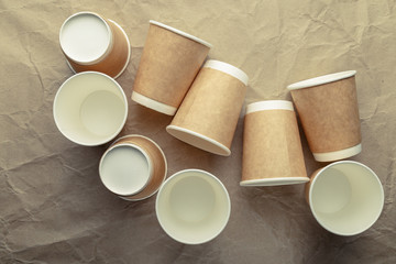 Paper cups for coffee on a light crumpled paper background.