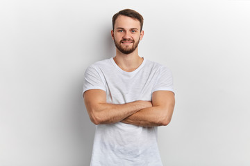 man in stylish T- shirt standing with crossed arms isolated on white background. close up portrait....