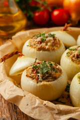 Onion baked with cheese stuffed with minced meat. Front view.  Served in parchment.