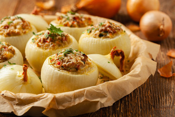 Onion baked with cheese stuffed with minced meat. Front view.  Served in parchment.