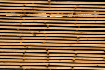 Piles of wooden boards in the sawmill, planking. Warehouse for sawing boards on a sawmill outdoors. Wood timber stack of wooden blanks construction material. Industry.