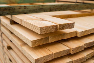Piles of wooden boards in the sawmill, planking. Warehouse for sawing boards on a sawmill outdoors....