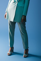 cropped view of african american woman in suit on blue background