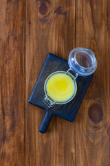 Ghee butter in a jar on a dark wooden board.