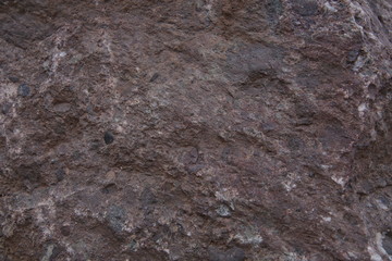 The texture of natural mountain stone. Burgundy brown color stone structure. Background, pattern, banner.