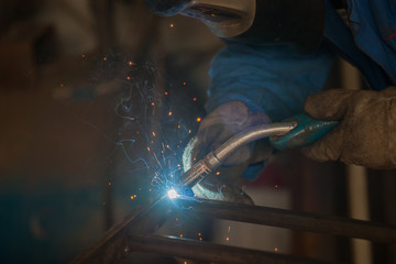worker with protective mask welding metal