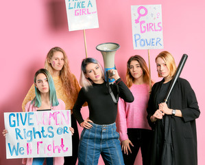 five friendly girls, young caucasian fighters for women rights use megaphone and posters isolated...
