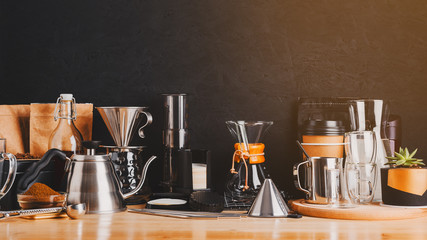 Accessories and utensils for making coffee drinks on a wooden table, coffee shop interior