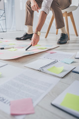 cropped view of scrum master holding marker pen near sticky notes