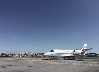Fototapeta na wymiar Private jet parked in airport yard preparing for boarding
