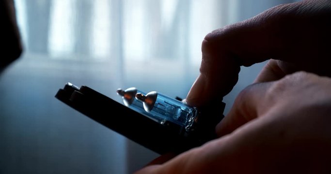 A man holding a set of car Xenon headlights and removing one of the bulbs for replacing - Close up
