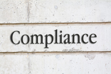 written Compliance word on concrete wall background
