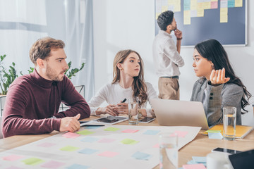selective focus of multicultural scrum masters talking in office