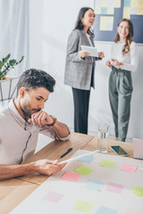 selective focus of mixed race scrum master using digital tablet near businesswomen