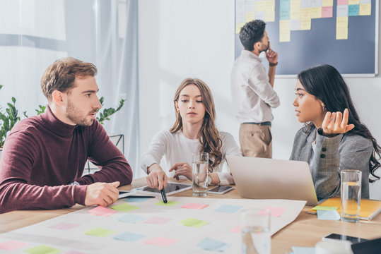 selective focus of multicultural scrum masters speaking in office