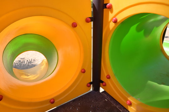 Green And Yellow In Tunnel Tube Of Slide In Sand Playground