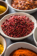 Pink peppercorn and variety spices and herbs in bowls
