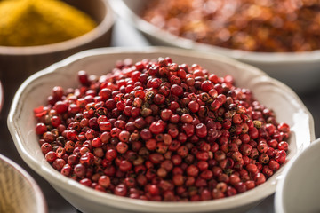 Pink peppercorn and variety spices and herbs in bowls