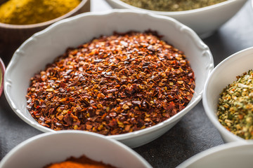 Ground chilli pepper and variety spices and herbs in bowls
