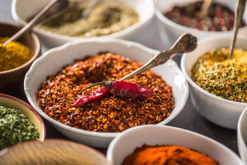 Ground chilli pepper and variety spices and herbs in bowls