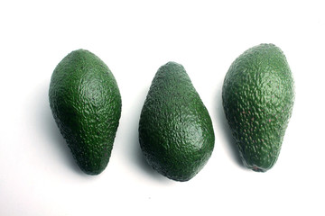 three avocado isolated on white background flat lay