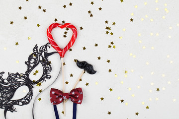 lollipops, decoration , bow tie and black mask on white background with golden stars. Valentines day background.