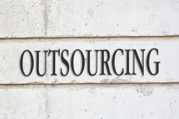 Written OUTSOURCING word on concrete wall background