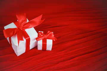 Holiday concept valentine's day. Two gifts in white wrapping paper on a red background. Layout with space for your text. Day of big discounts - sale.