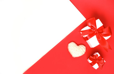 Holiday concept valentine's day. A white heart made of cotton yarn and two boxes with a gift in...