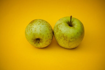 Bio green apples on a yellow background