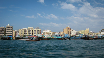Fototapeta premium modern buildings on coast of bay deira creek and old-fashion traditional boats in Dubai, UAE