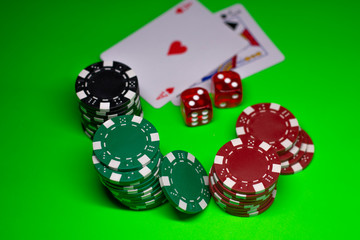 Gambling chips, poker cards on the green poker cloth