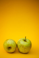Bio green apples on a yellow background