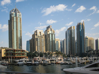 Fototapeta na wymiar modern skyscrapers against the blue sky in the Dubai Marina district, boats and yachts in the foreground, UAE