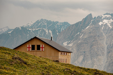 Obraz premium View at small mountain house with flags