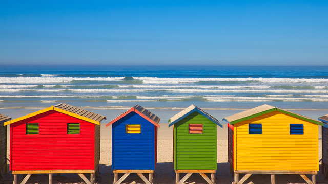 four colourful huts on beach