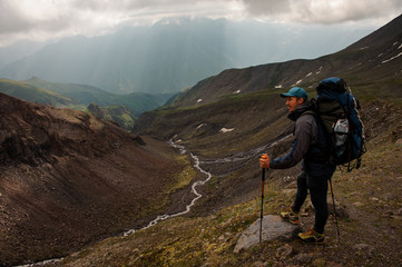 Fototapeta premium Equipped traveller rests on top of hill