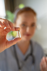 Focused photo on female hand that holding capsule