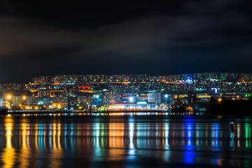 Obraz na płótnie Canvas night Murmansk, city lights reflected in the Bay and the ships standing in the port