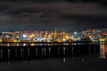 Fototapeta na wymiar night Murmansk, city lights reflected in the Bay and the ships standing in the port