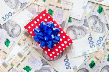 gift box with a bow lies on paper money, Ukrainian hryvnia