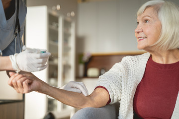 Positive delighted senior patient listening to her doctor