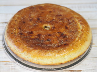 Round homemade pie with cabbage and river fish pike. Wooden rustic white table. Homemade food.