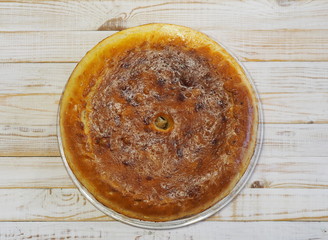Round homemade pie with cabbage and river fish pike. Wooden rustic white table. Homemade food.
